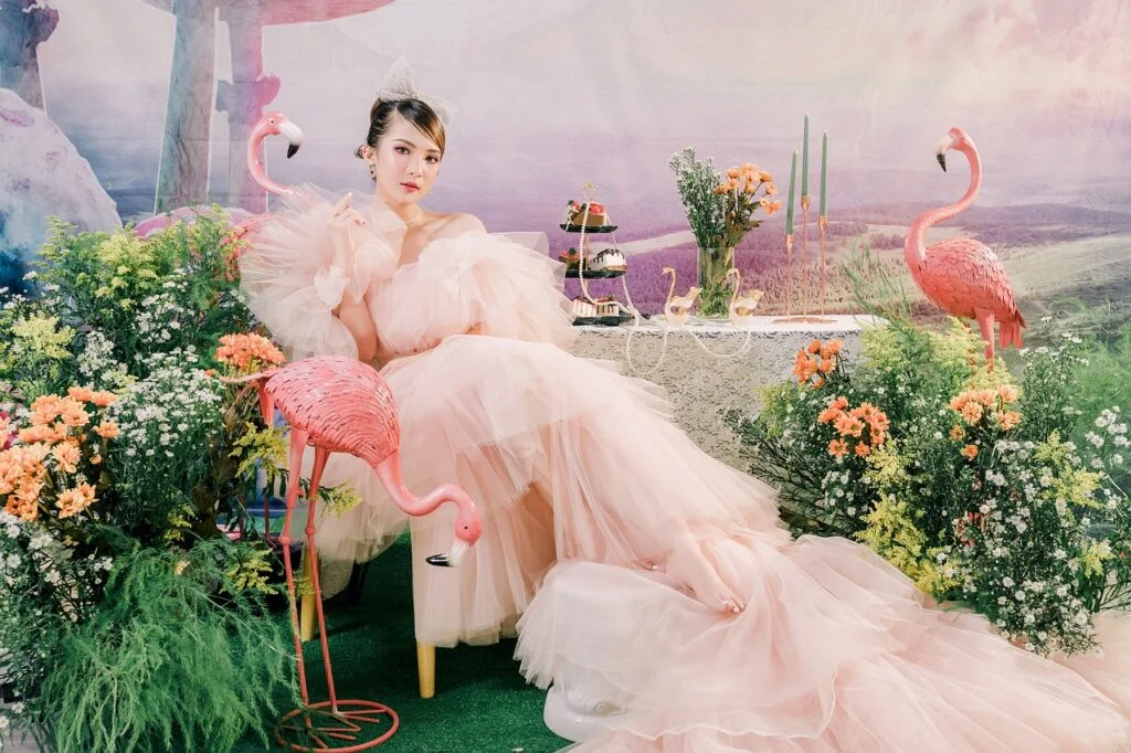 Pet flamingo names - A woman wearing a pink dress with flamingo garden decorations in a garden
