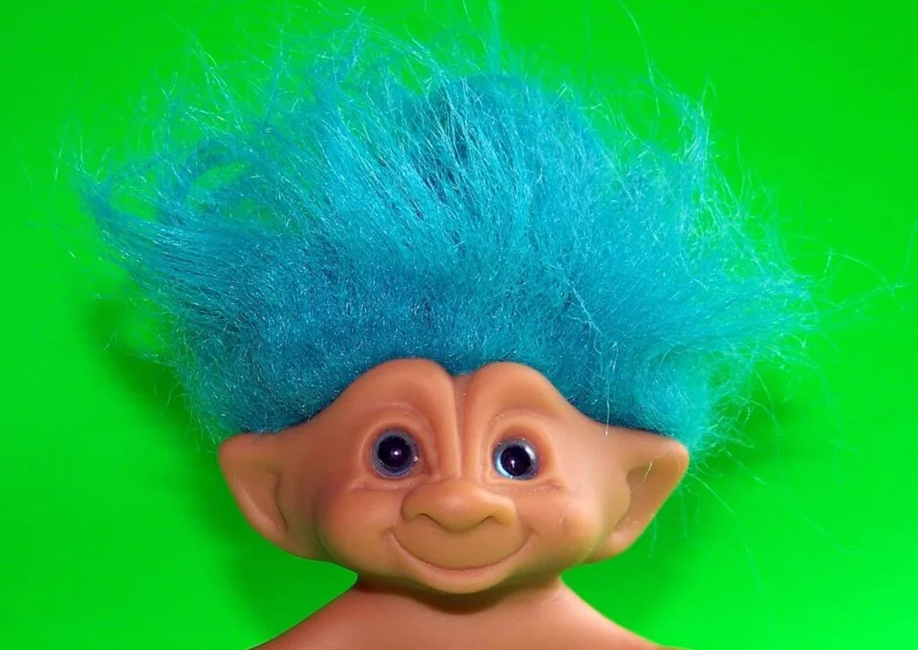Troll name ideas - A cute troll toy on green background